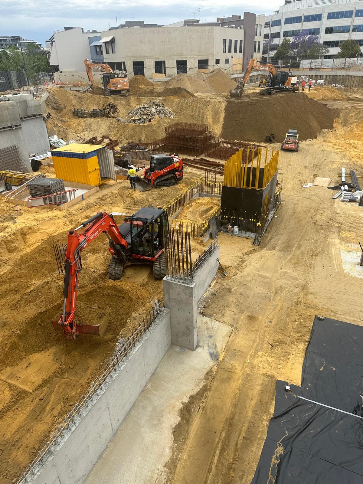Large civil excavation with concrete columns and rebar, urban Australian site
